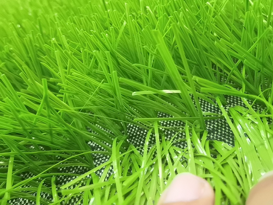 Why does football artificial grass perform better than real grass in use