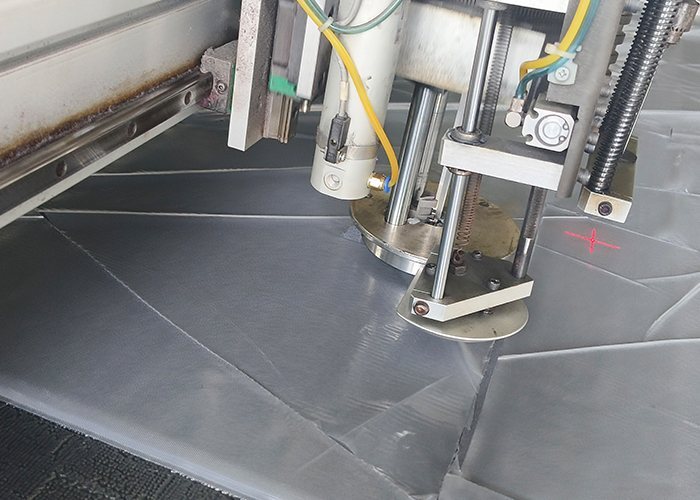 CAD cutting head shaping cover panels on a computer-controlled cutting table
